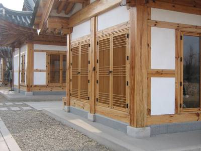 A traditional Korean hanok with wooden lattice doors and a tiled roof