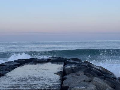 A stone jetty reaching into the sea at sunrise